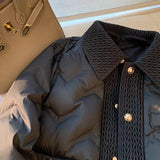 Navy blue quilted puffer jacket with a high-collar design, featuring long sleeves and a stylish, insulated winter coat construction.