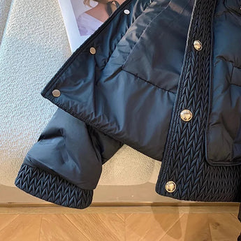 Navy blue quilted designer puffer jacket with a high collar, featuring long sleeves and a tailored fit, exemplifying a stylish and comfortable winter coat.