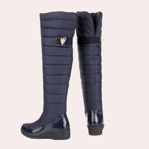 Navy blue quilted insulated women's winter boots featuring a glossy toe design, styled as knee-high boots.