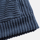 Navy blue ribbed corduroy pullover hoodie featuring a high collar and long sleeves, crafted from a textured fabric with a pattern similar to denim and woolen material.