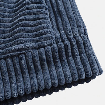 Navy blue ribbed corduroy pullover hoodie featuring a high collar and long sleeves, crafted from a textured fabric with a pattern similar to denim and woolen material.