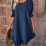 Woman wearing a navy blue ruffle dress with round neck and short sleeves, showcasing a chic and casual summer fashion style.
