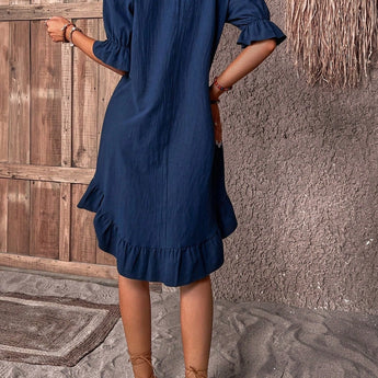 Woman wearing a navy blue ruffle dress with round neck, short sleeves, and casual summer style.