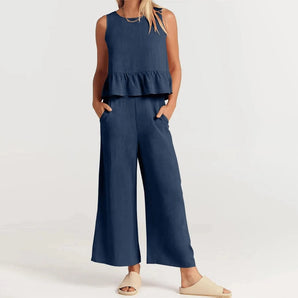 Navy blue sleeveless wide-leg peplum jumpsuit showcasing a stylish and elegant design suitable for office wear, featuring a fitted waist, round neckline, and loose wide legs for a chic, fashionable look.