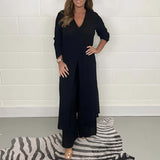 Navy blue wide-leg jumpsuit with 3/4 sleeves, designed for plus-size evening wear, featuring a tailored waist and a classic neckline.