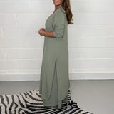 Navy blue wide-leg jumpsuit with 3/4 sleeves, designed as plus-size evening wear, showing details of the shoulder, arm, waist, and neck area.