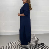 Navy blue wide-leg jumpsuit with 3/4 sleeves, designed for plus-size evening wear, featuring a flattering waist and one-piece garment style, displayed on a mannequin or model.