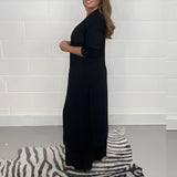 Navy blue wide-leg jumpsuit with 3/4 sleeves, designed as plus-size evening wear featuring a one-piece garment style and defined waist.