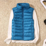Navy blue women's lightweight quilted puffer vest with a high collar, featuring a sleek design, ample pockets, and a vibrant azure color, shown in size 4XL.