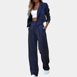 Navy blue women's pinstripe suit featuring a blazer and high-waisted trousers, styled with a dress shirt, ideal for professional workwear settings.