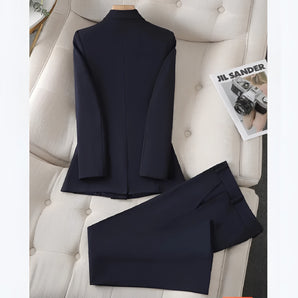 Navy blue women's tailored suit featuring a slim blazer with a classic collar and long sleeves, paired with high-waist trousers, displayed against a plain white background.
