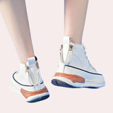 
Navy blue zipper wedge sneakers with a chunky platform worn on a person's feet, showcasing modern fashion design and providing a stylish look.