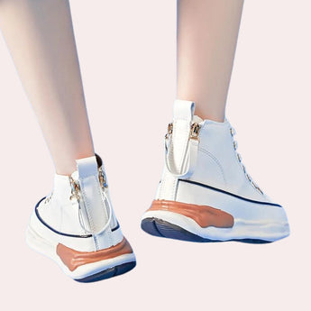 
Navy blue zipper wedge sneakers with a chunky platform worn on a person's feet, showcasing modern fashion design and providing a stylish look.