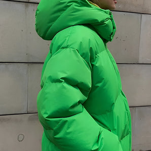 Neon green oversized puffer jacket with long sleeves, featuring a fashion-forward design suitable for winter, resembling a windbreaker or parka style.