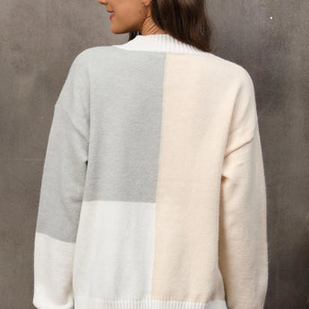 Neutral tone color-block sweater featuring long sleeves and a cozy knit design perfect for fall, with a stylish combination of grey and other muted tones that enhance its trendy and versatile look.