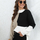 
A woman smiling and wearing a trendy neutral tone color-block sweater in black, size XL. She is accessorized with sunglasses and holding a beverage. The sweater features a stylish neckline and long sleeves, ideal for fall fashion.