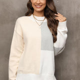 Neutral tone color-block sweater worn by a smiling woman, featuring long sleeves and a stylish neckline, showcasing trendy women's fall knitwear.