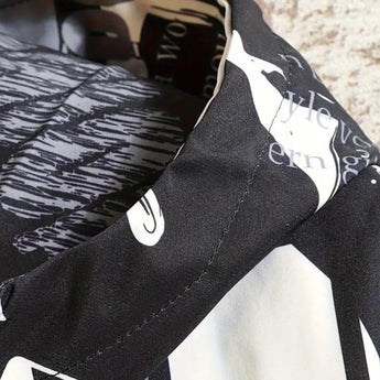 Black and white typographic design shirt featuring newspaper print patterns, short sleeves, and a casual fit.