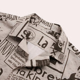 
A modern vintage urban fashion top featuring a newspaper print design with monochrome patterns and text details, styled as a shirt with sleeves.
