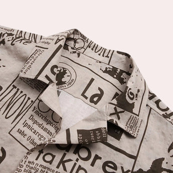 
A modern vintage urban fashion top featuring a newspaper print design with monochrome patterns and text details, styled as a shirt with sleeves.