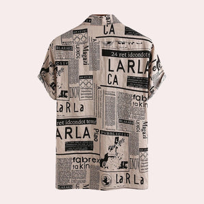 A modern vintage urban fashion top featuring a newspaper print design with various text and illustrations, long sleeves, and a distinct pattern on the fabric.