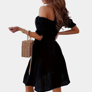 
A stylish off-shoulder black evening dress for women featuring a flattering A-line silhouette with puffed sleeves. The dress's elegant design highlights the shoulders and arms, suitable for formal occasions.