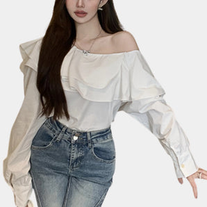 Off-shoulder white blouse with a ruffle neckline and long sleeves, showcasing the shoulder and arm area.