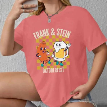 Oktoberfest-themed cartoon t-shirt featuring a whimsical design of "Frank & Stein" characters enjoying a beer festival, printed on a rose-colored fabric. The shirt is displayed in an XL size, with emphasis on the sleeves and neckline.