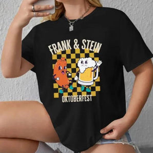 A black Oktoberfest Cartoon Tee featuring a humorous design of "Frank & Stein" characters, suitable for beer festival enthusiasts. The shirt displays detailed imagery and text with a playful font, styled with short sleeves and a casual fit, available in size XL.