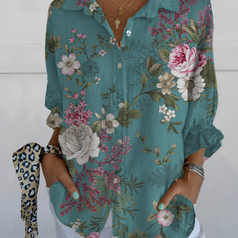 
An olive green women's blouse featuring a bird print, with a V-neck and ruffle sleeves.
