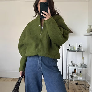 Olive green cropped bomber jacket for women with long sleeves and ribbed waist, styled as urban streetwear, displayed on a mannequin against a plain backdrop.
