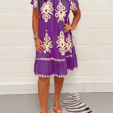 Olive green floral bohemian dress with a casual chic style, featuring a flowy design and short sleeves, suitable for summer festivals. The dress is shown in size 5XL and is highlighted with subtle purple and white floral patterns.