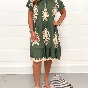 Olive green floral bohemian dress in size 5XL featuring a casual chic style suitable for summer festivals. The one-piece garment has a flattering day dress design with a defined waist, short sleeves, and a modest neckline.