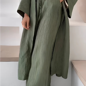 Olive green high waisted pleated maxi skirt with a bohemian crinkled style, featuring a flowing design and elegant pleats.