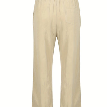 Olive green lightweight harem pants for unisex, shown as baggy summer trousers with an elastic waist, modeled on a person.