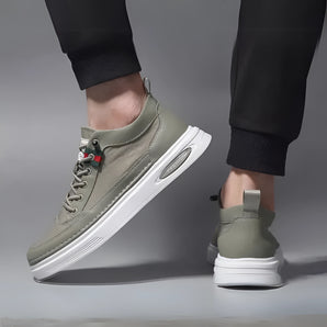 Olive green low-top men's urban casual sneakers made of breathable canvas, featuring a white sole and designed for comfort and style during walking or casual outdoor activities.
