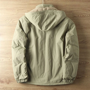 Olive green men's lightweight hooded windbreaker jacket hanging on a clothes hanger, showcasing its water-resistant material, long sleeves, and subtle design details.