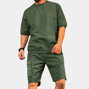 Olive green men's summer streetwear featuring a light green crew neck tee and cargo shorts in a camouflage pattern, shown on a person wearing size 2XL.