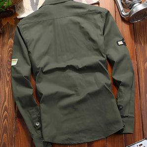 Olive green men's tactical long sleeve military shirt featuring a button-up front, a collared design, and a pocket on the chest. The shirt appears durable and breathable, suitable for outdoor activities.