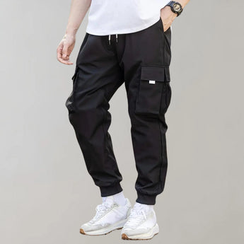 
A pair of olive green men's tapered cargo pants, showcasing a lightweight utility fashion design, with visible pockets and a modern fit.