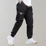 Olive green men's tapered cargo pants designed for lightweight comfort and utility fashion, shown on a model with emphasis on the knee and thigh area.