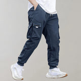 Olive green men's tapered cargo pants, showcasing a lightweight and fashionable utility design, with visible pockets and seams. A person models the pants, highlighting their fit around the thighs and knees.
