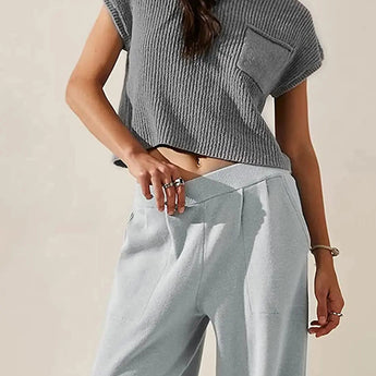 A woman wearing an olive green short sleeve knit sweater with a pocket, showcasing its lightweight and breathable summer knitwear design.