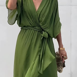 Olive green silk V-neck midi wrap dress with short sleeves, worn by a fashion model, highlighting elegant summer style.