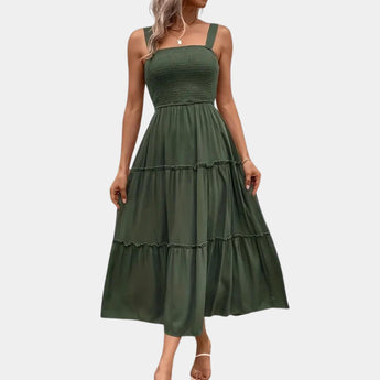 Olive green smocked bodice strappy midi dress featuring a fitted bodice, shoulder straps, and a flowing skirt that falls to mid-calf.