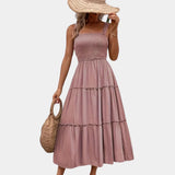 Olive green smocked bodice strappy midi dress with thin shoulder straps, featuring a fitted smocked bodice and flowing skirt suitable for daytime wear.