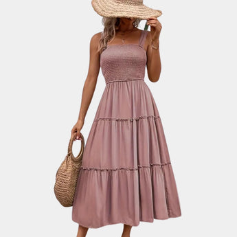 Olive green smocked bodice strappy midi dress with thin shoulder straps, featuring a fitted smocked bodice and flowing skirt suitable for daytime wear.
