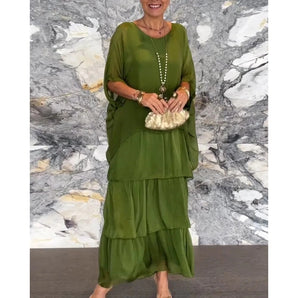 Elegant olive green tiered maxi dress with a sleeveless design, flattering for larger sizes, shown in a 4XL. The dress features a defined waist, flowing layers, and a smooth textile finish, ideal for summer evening occasions.