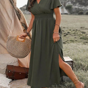 Olive green V-neck midi dress with a flowy design and elastic waist, suitable for summer wear, shown in size 4XL. The dress features short sleeves and is captured in a photograph using flash photography.
