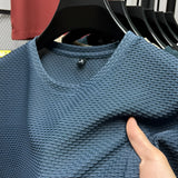 Unisex waffle knit sweater in olive green with long sleeves and a waffle texture, designed for fall fashion.
